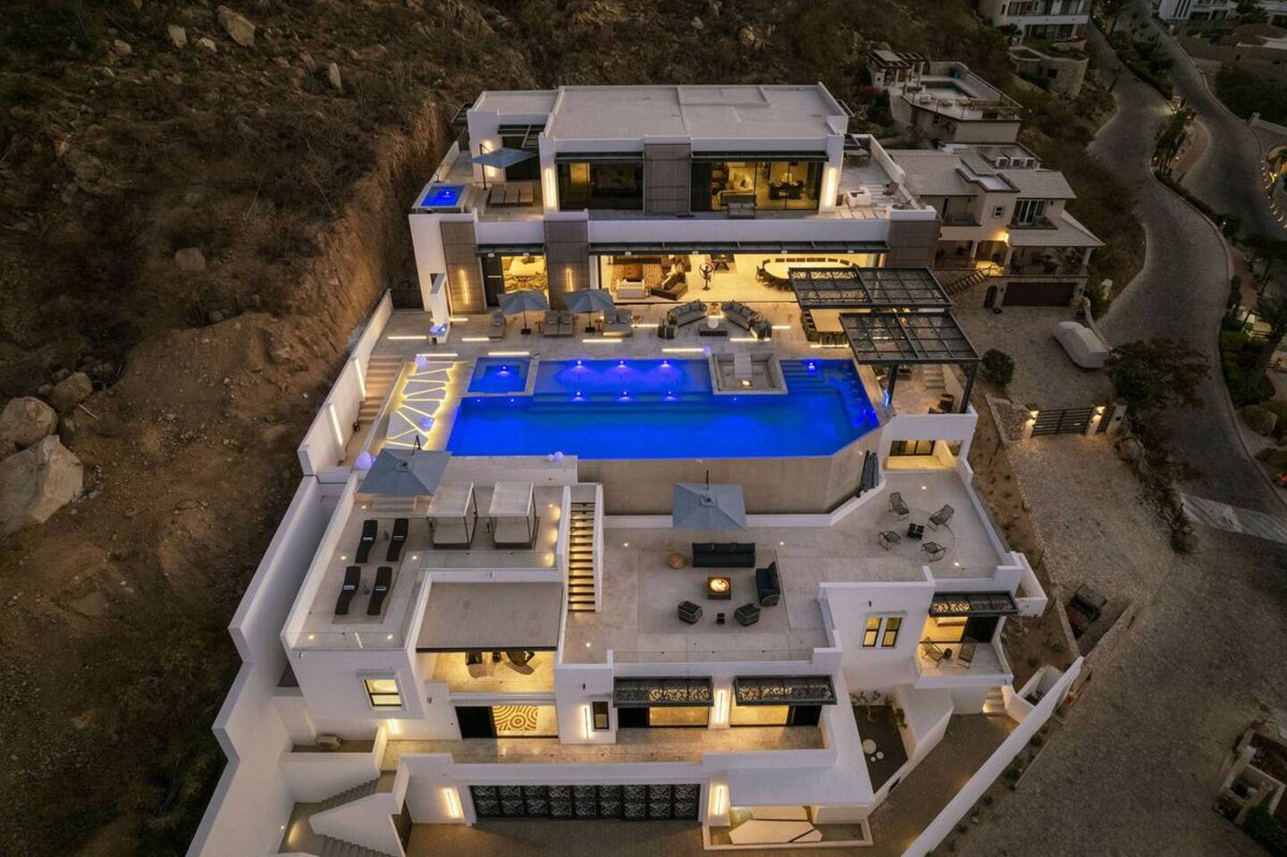 A modern villa lounge opening to the pool at dusk